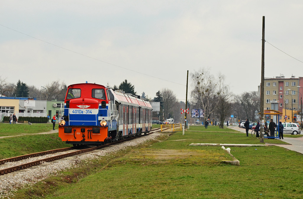 401Da-314+39WE-001
Fifka prowadzi 39WE-001, mijajÄc Osiedle Staszica w Pruszkowie. Nowa jednostka NEWAGu poprzedniej nocy przechodziĹa testy zwiÄzane z kontrolÄ skrajni, a wiec wpisywania siÄ pojazdu w Ĺuki na terenie zaplecza warsztatowego i torĂłw postojowych.

