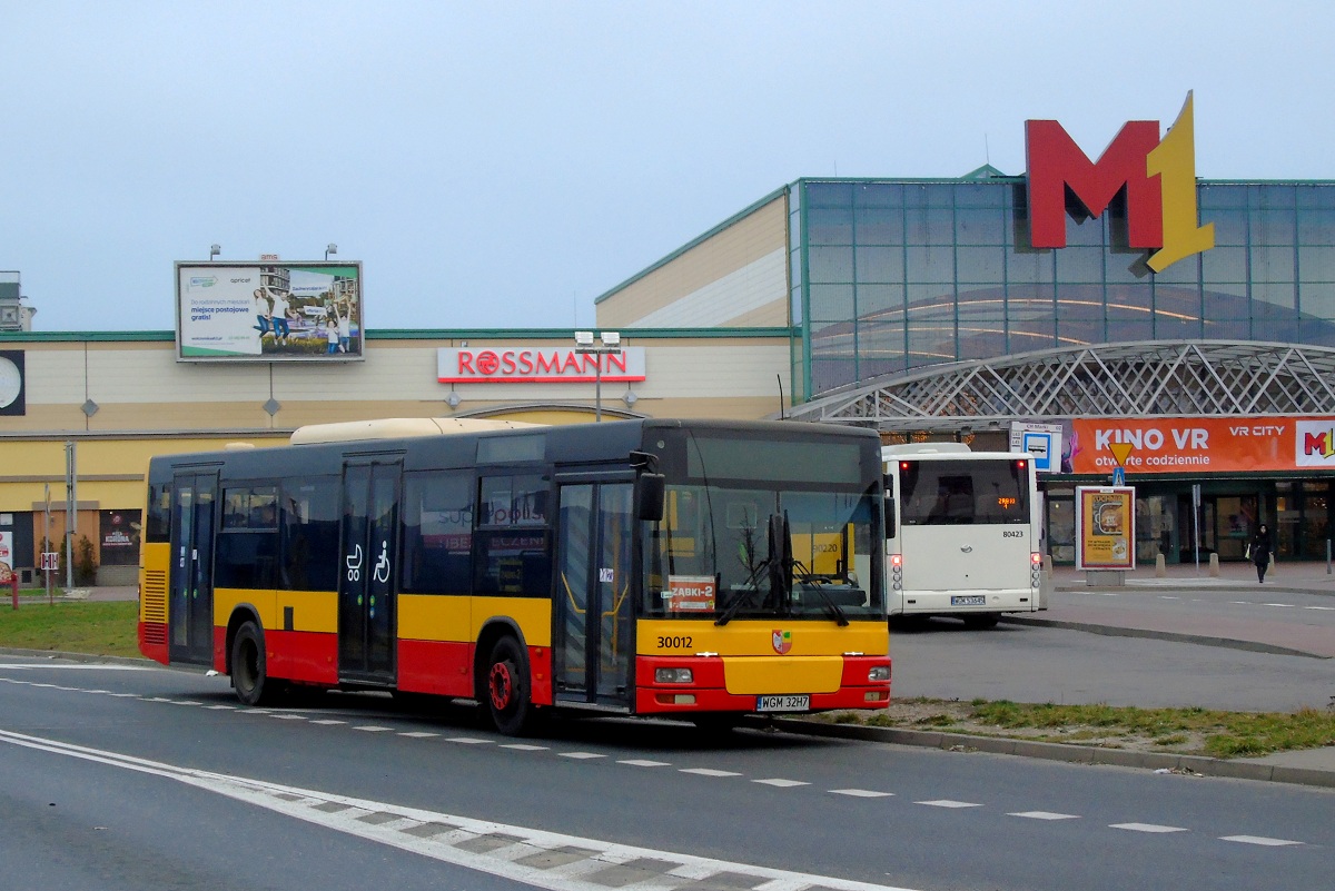 30012
SAM stoi w okolicach pÄtli przy CH M1 Marki w trakcie przerwy w wykonywaniu kursĂłw na linii Z-2. W tle widoczny jest tyĹ ZAZ-a A10C3A #80423 ktĂłry oczekuje by rozpoczÄÄ kurs linii Z-1 w relacji CH Marki (9:20)-CH Marki (10:07) p. ZÄbki DzikÄ (9:40). 
TytuĹowy wĂłz w ostatnim czasie w zwiÄzku z nowym kontraktem w ZÄbkach zostaĹ przemalowany w aktualny schemat WTP (byĹ on jednym z kilku dozwolonych schematĂłw przez UM ZÄbki). 

