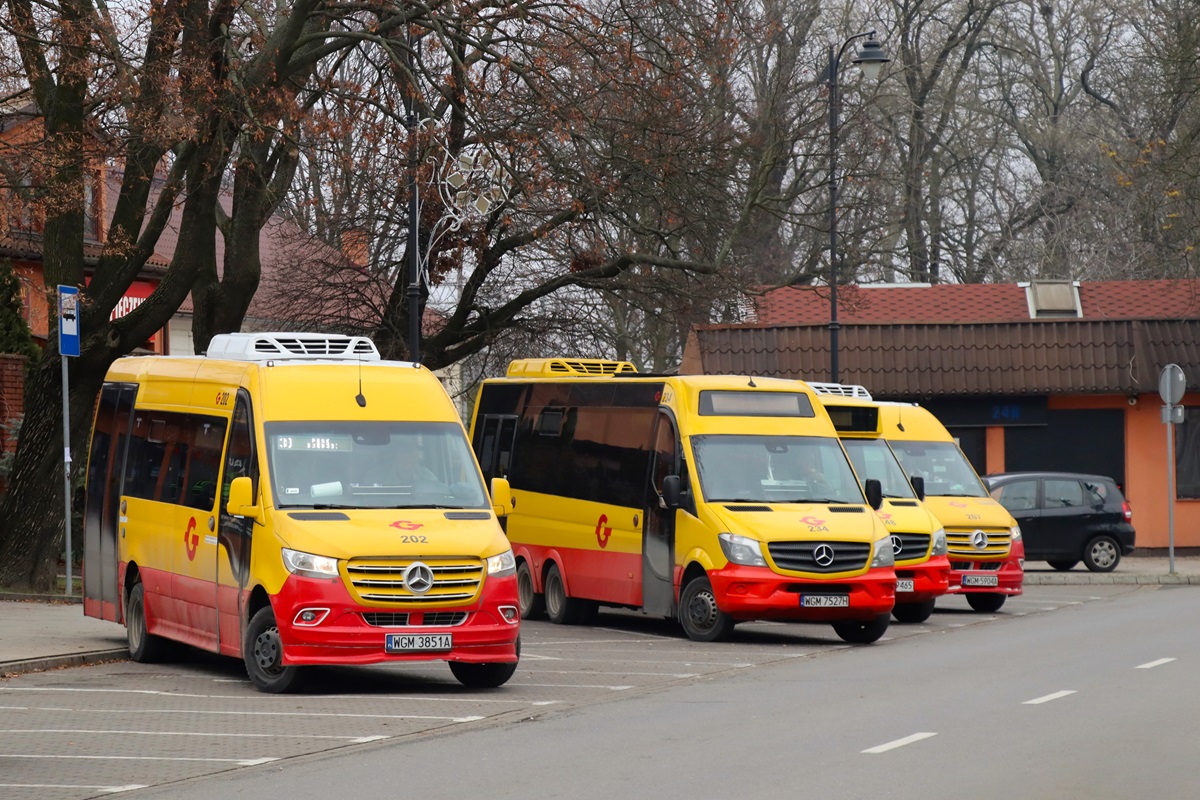 202
TytuĹowy Sprinter stoi na przystanku przyjazdowym âGrodzisk Maz. Dw. PKP 02â w oczekiwaniu na przejazd na przystanek odjazdowy âGrodzisk Maz. Dw. PKP 01â gdzie rozpocznie wykonywaÄ kurs linii numer 30: Grodzisk Maz. Dw. PKP (13:20)-PieĹki SĹubickie (14:16). Obok stojÄ w oczekiwaniu na podjÄcie pracy Mercedes-Benz 519 CDI / Eurotrans XXI Trituro City 84 #234, Mercedes-Benz 519 CDI #248 i Mercedes-Benz 516 CDI / Mercus MB Sprinter City #207.
