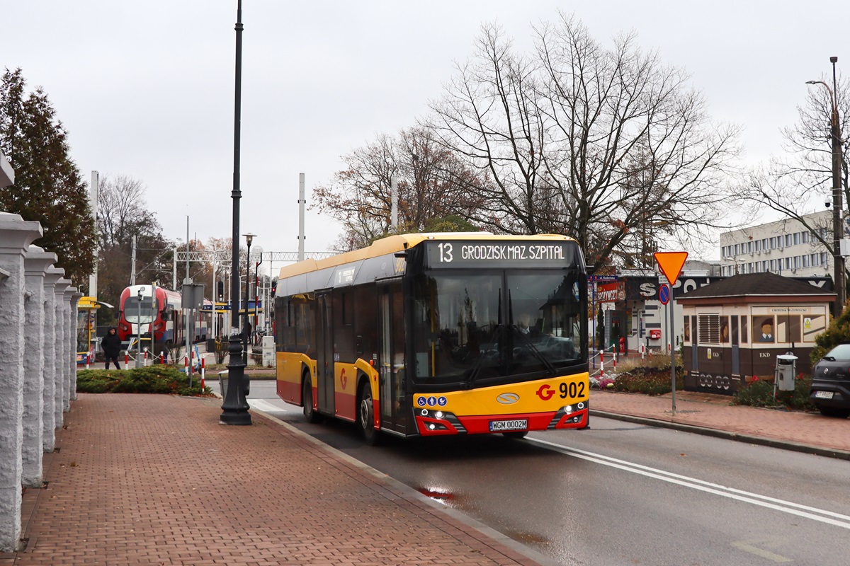 902 (24082)
Solaris jedzie jako kurs linii numer 13: BĹonie Centrum Sportu (9:55)-Grodzisk Maz. Szpital (10:47). 
W tle widoczny jest EN97-011 po skoĹczonym biegu jako kurs 137 pociÄgu osobowego WKD A1 w relacji Warszawa ĹrĂłdmieĹcie WKD (9:50)-Grodzisk Mazowiecki RadoĹska (10:45). NastÄpnie skĹad zjedzie na szopÄ. 
