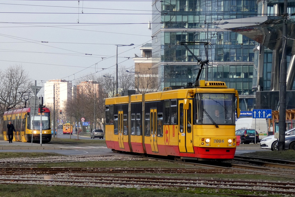 3004 i 3151
U-boot jedzie w obsłudze kursu linii numer 24 w relacji Nowe Bemowo (12:36)-Gocławek (13:38). W tle na przystanku „Rondo Daszyńskiego 05” stoi Swing w obsłudze kursu linii numer 1 w relacji Annopol (12:31)-Banacha (13:15). 
